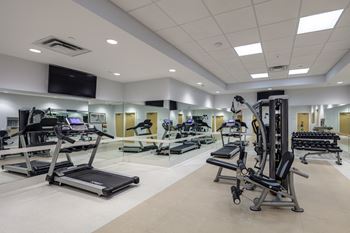 a gym with treadmills and other exercise equipment in a large room